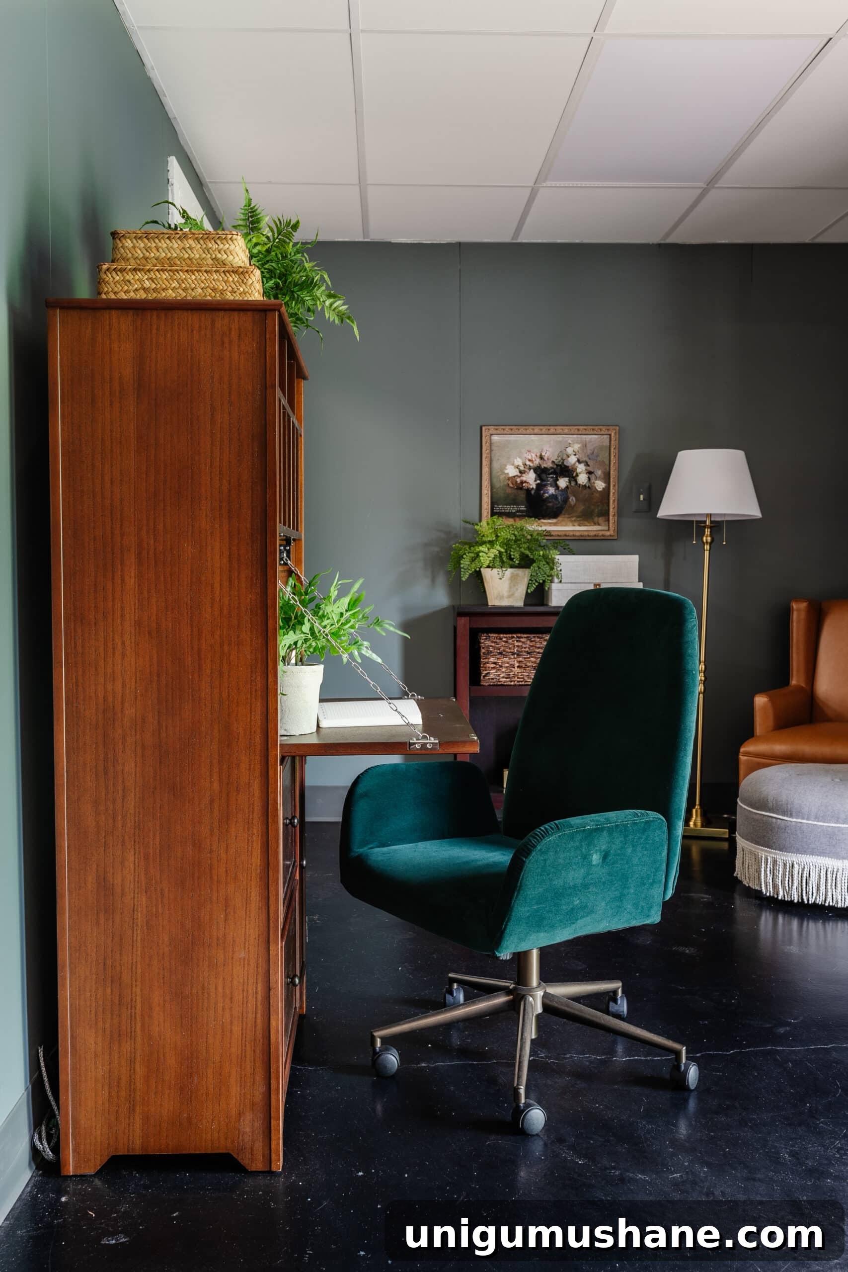 wooden secretary desk and green desk chair in an office