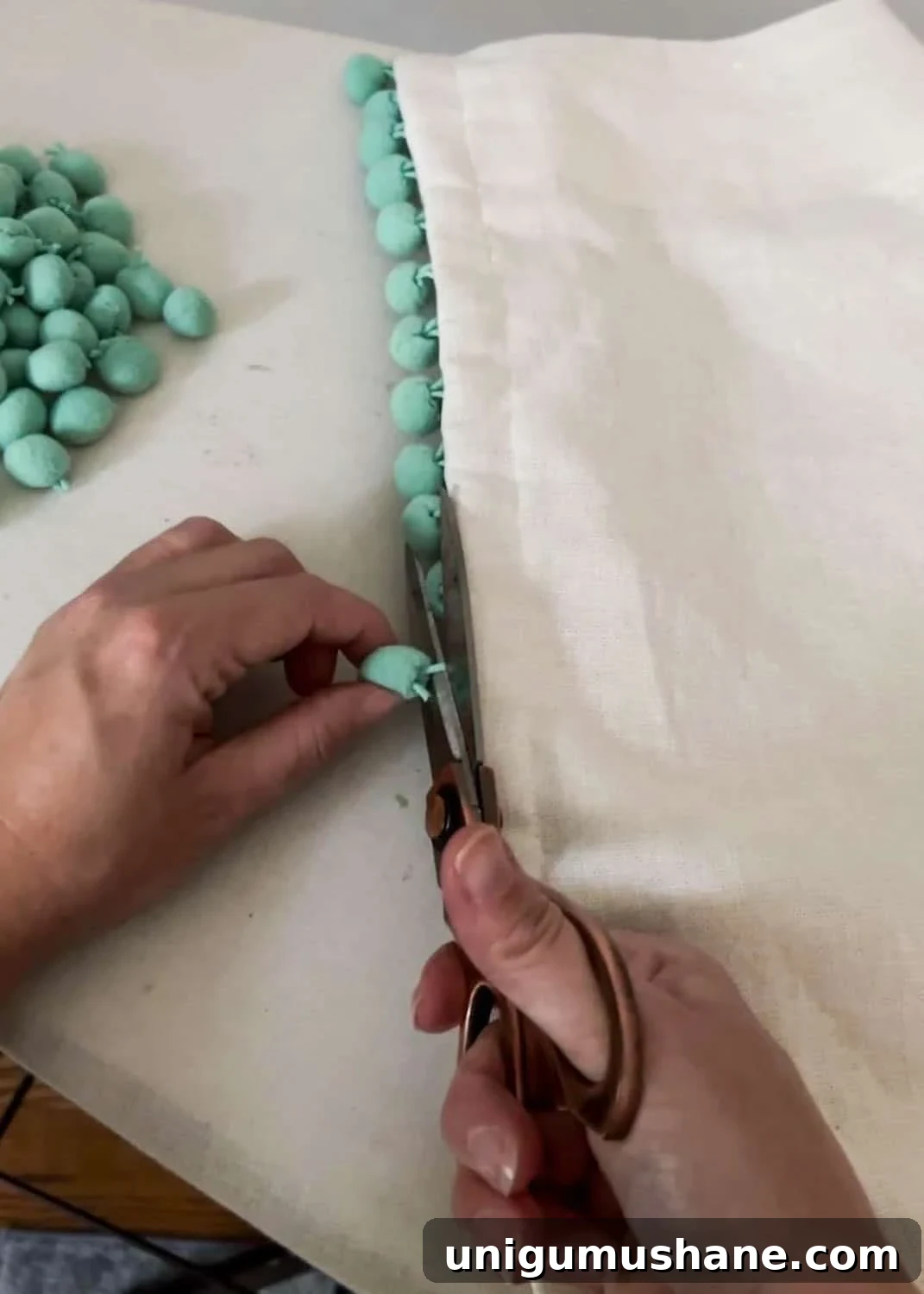 How to Make No-Sew Curtains with Trim 5 removing pom poms from curtains with scissors