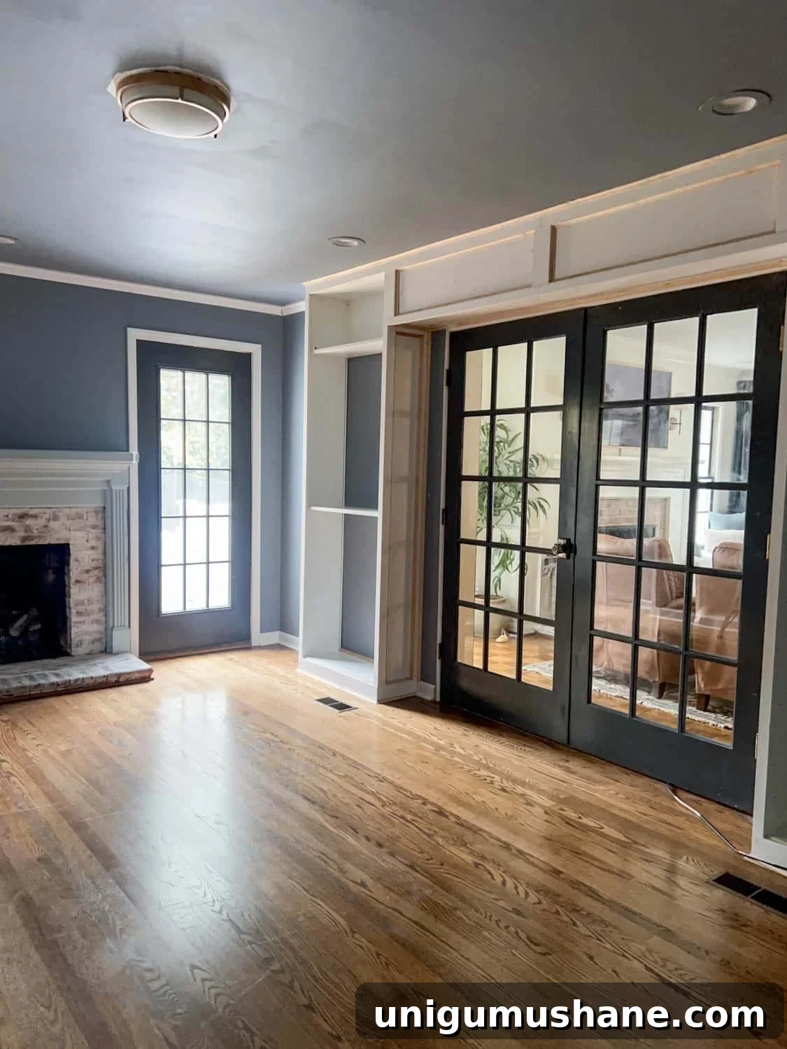 How to Build a Hidden Projector Screen with an IKEA Hack 3 French doors surrounded by built in bookcases