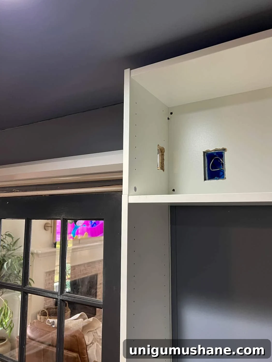 How to Build a Hidden Projector Screen with an IKEA Hack 6 cutting a hole in bookcase for outlet access