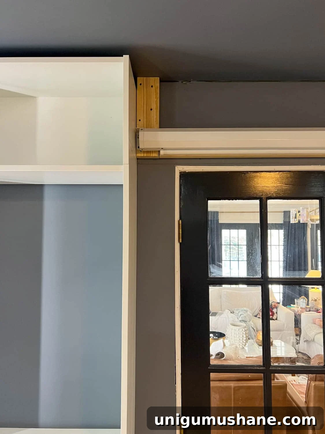 How to Build a Hidden Projector Screen with an IKEA Hack 7 hanging projector screen on wall with 2x4s
