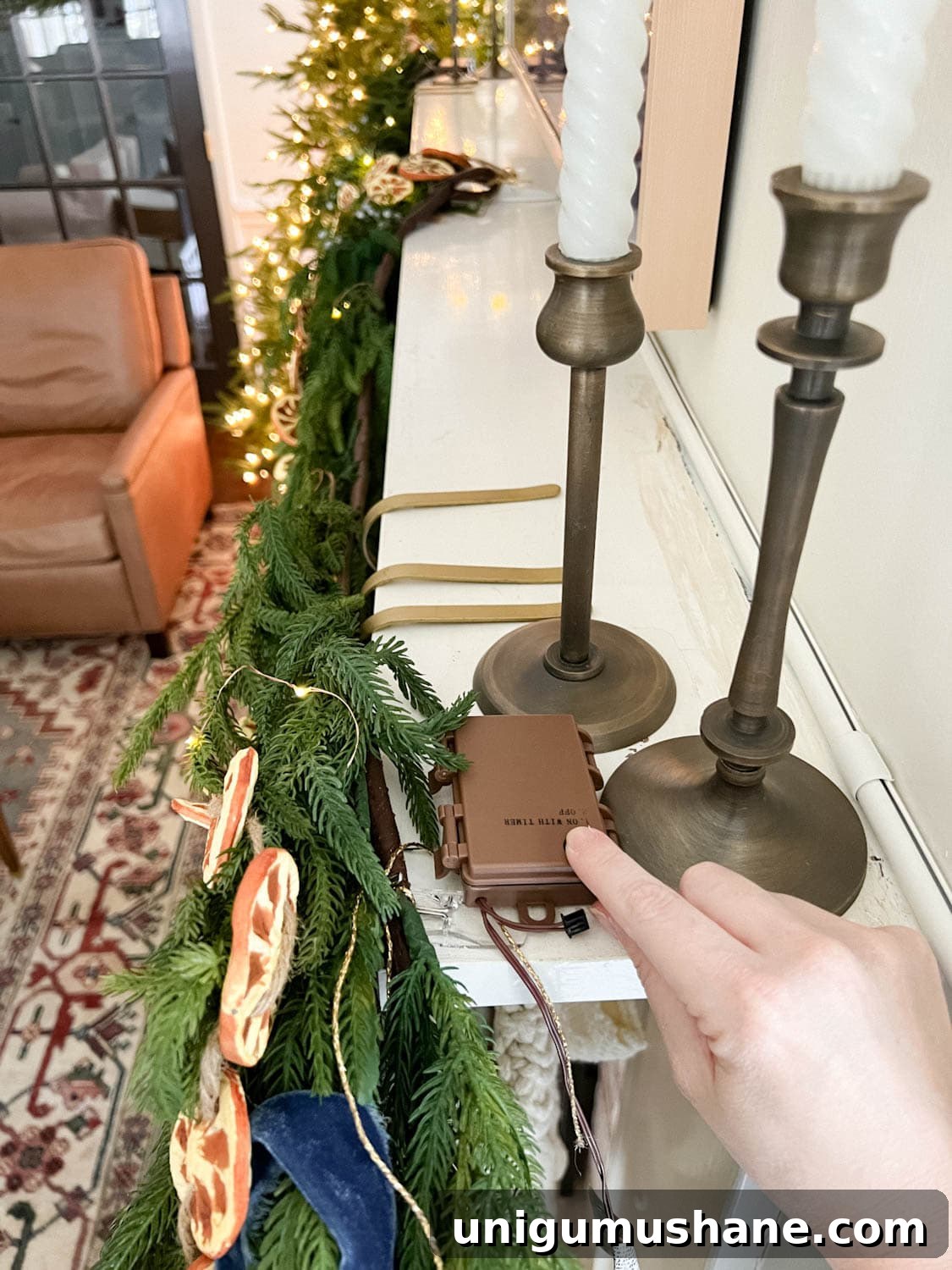 DIY Christmas Mantel Garland Ideas to Transform Your Fireplace 7 attaching fairy light battery pack to mantel with Command strip