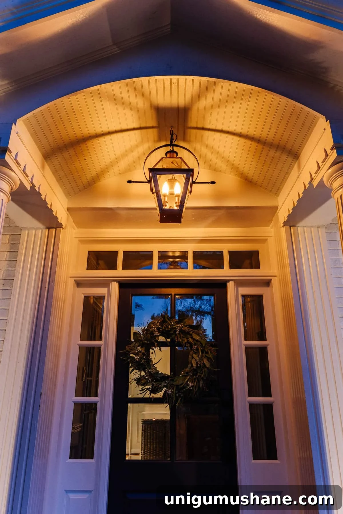 fake gas lantern on a front porch with flickering flame light bulbs at night