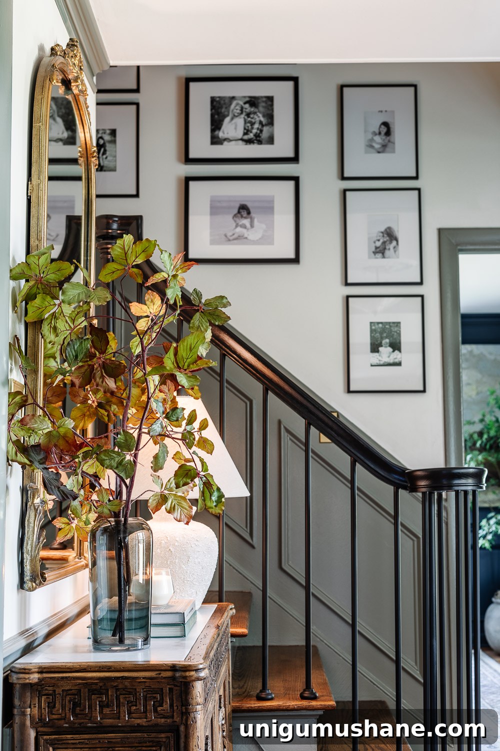 Stylish Entryway and Foyer Makeover Ideas Under $300 9 vase of tall fall stems on entryway table credenza and family gallery wall on staircase