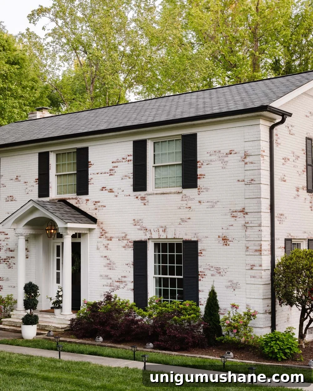16 DIY Curb Appeal Ideas to Transform Your Front Yard 29 limewashed brick colonial with solar lights