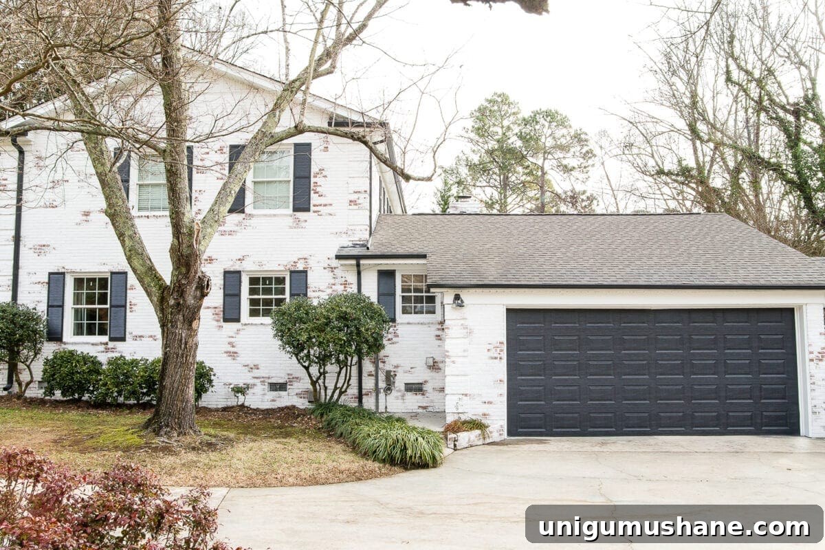 16 DIY Curb Appeal Ideas to Transform Your Front Yard 6 painted garage door in Behr Cracked Pepper and limewashed brick house