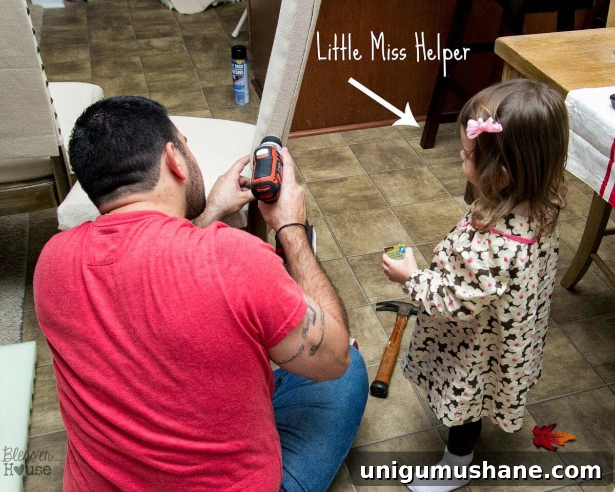 DIY No-Sew Knockoff Dining Chairs 13 Child helping hand nailheads to dad
