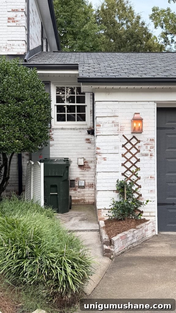 garage curb appeal with copper lanterns, star jasmine, and outdoor trash can hiding panels