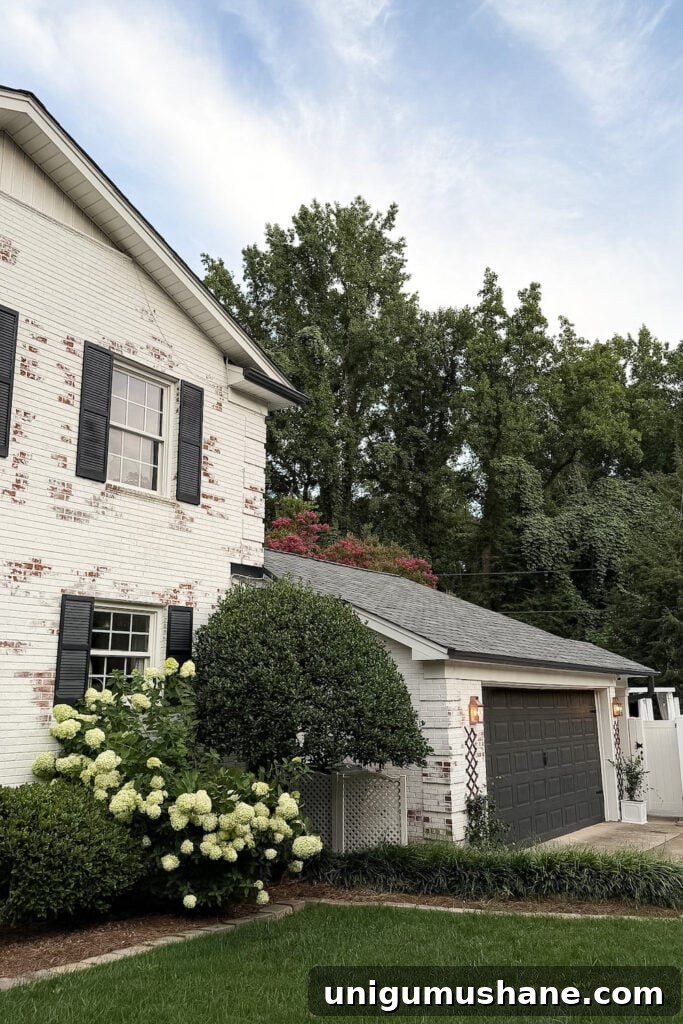 garage curb appeal with copper lanterns, star jasmine, and outdoor trash can hiding panels