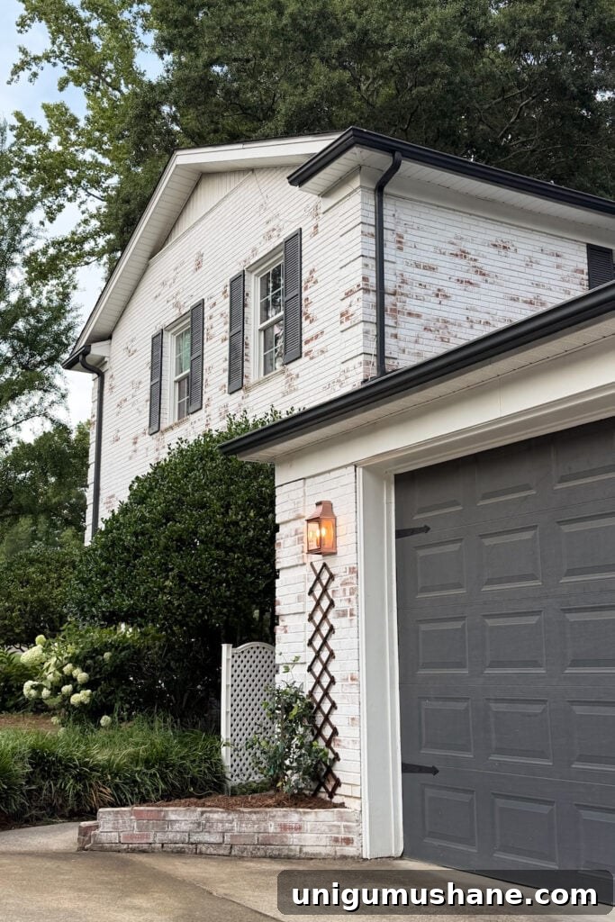 garage curb appeal with copper lanterns, star jasmine, and outdoor trash can hiding panels