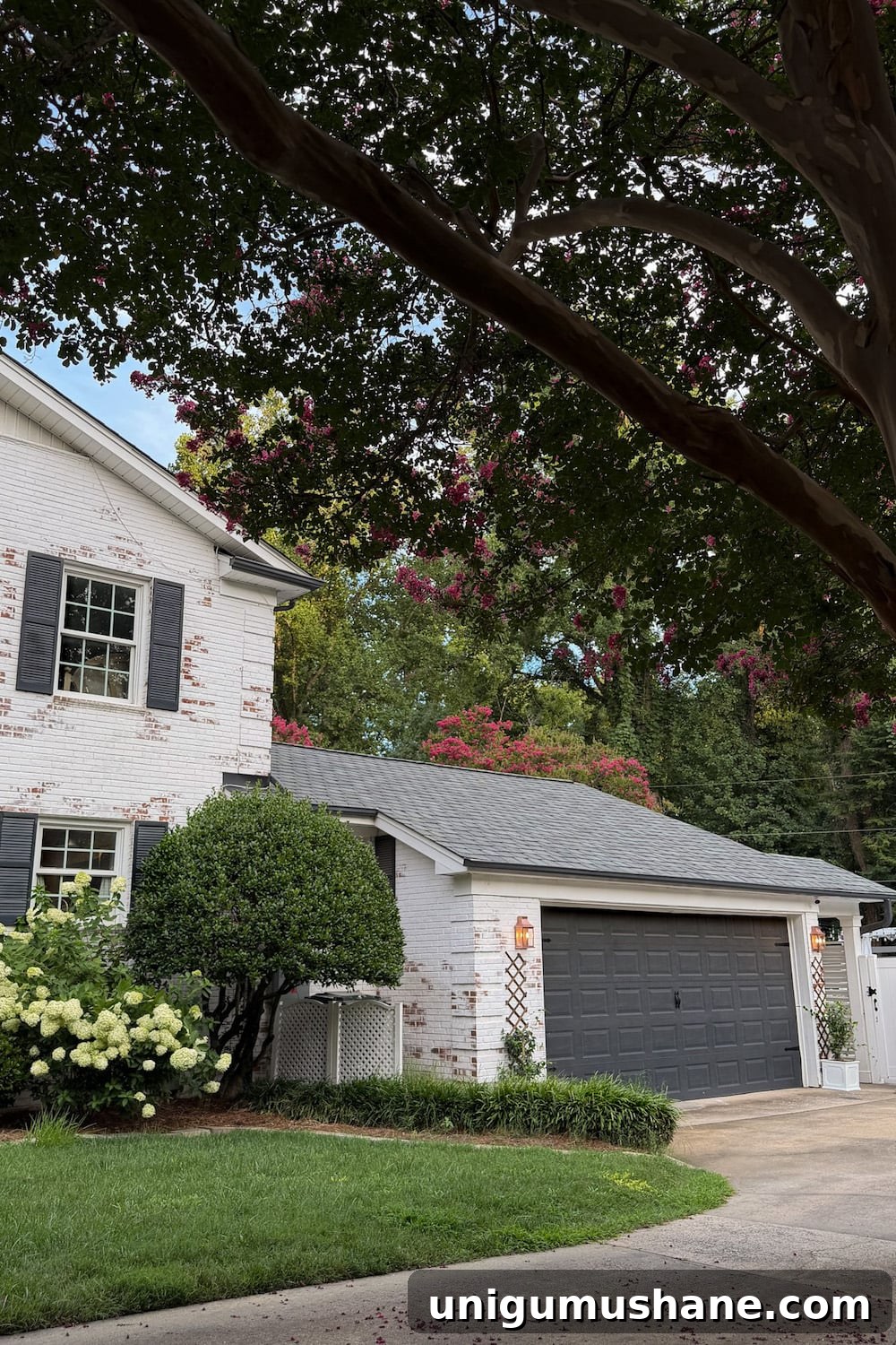 garage curb appeal with copper lanterns, star jasmine, and outdoor trash can hiding panels