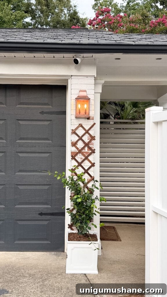 garage curb appeal with copper lanterns, star jasmine, and outdoor trash can hiding panels